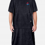 Person standing, wearing a black Swellone surf poncho.
