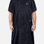 Person standing, wearing a black Swellone surf poncho.