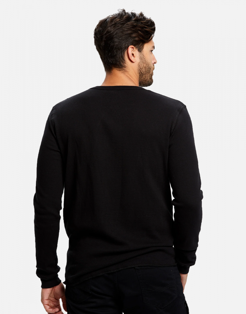 Man standing, back turned, wearing a black Swellone long sleeve thermal shirt.